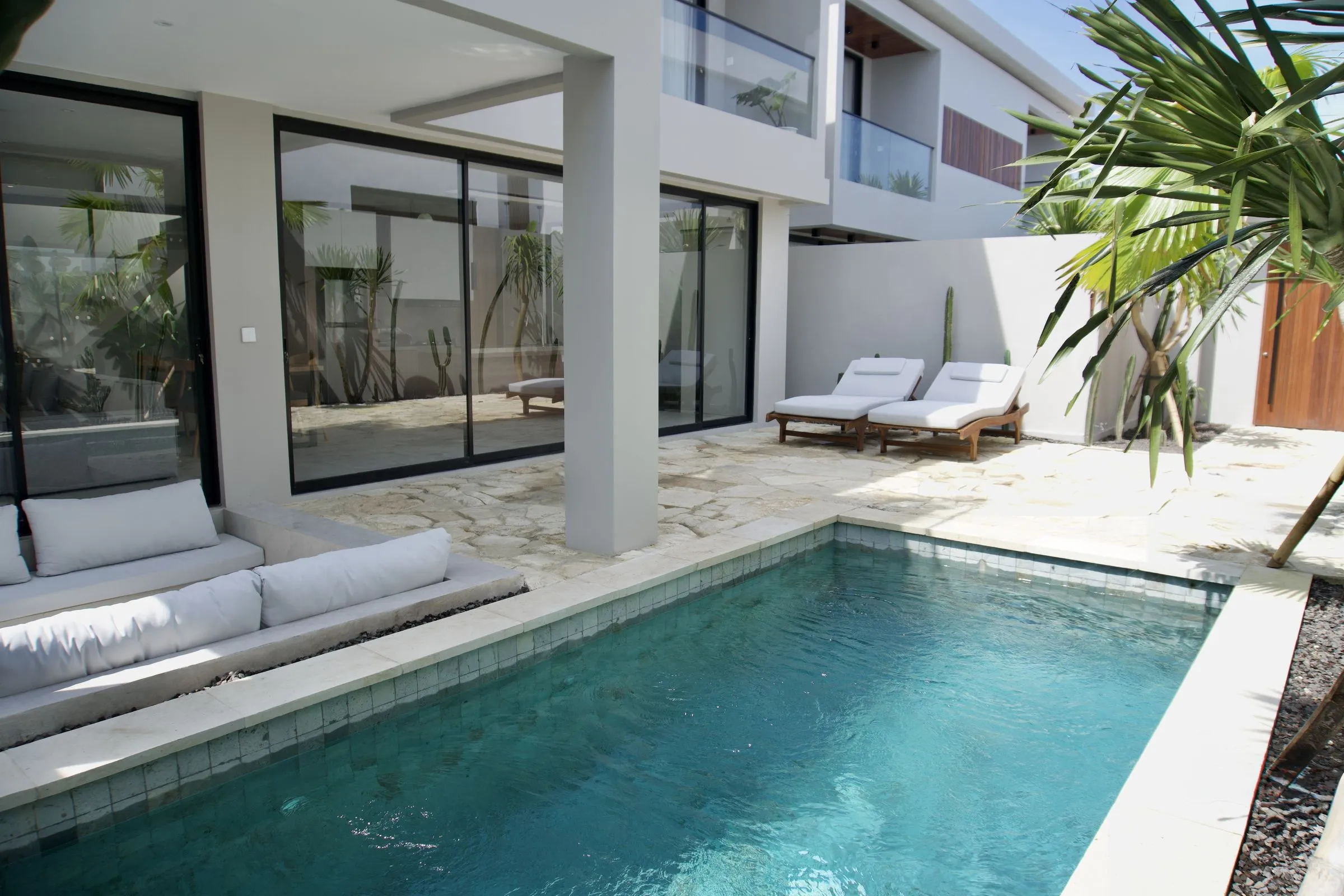 Two-storey white villa in Melasti, Ungasan: private pool, sunken lounge and sun loungers in a walled garden